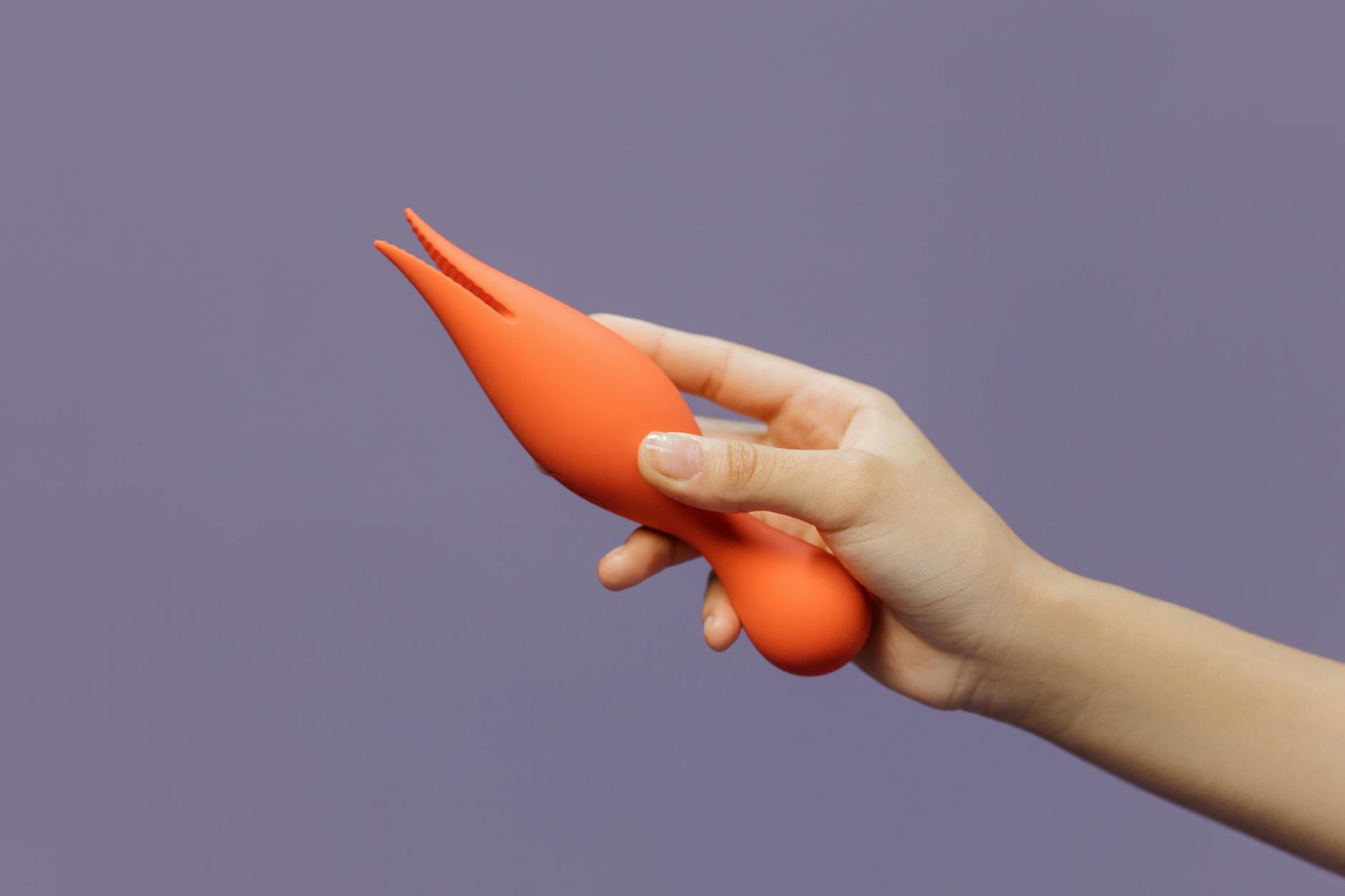 Close-up of a hand holding a lemon vibrator against a minimalist purple background, symbolizing gentle pleasure recovery