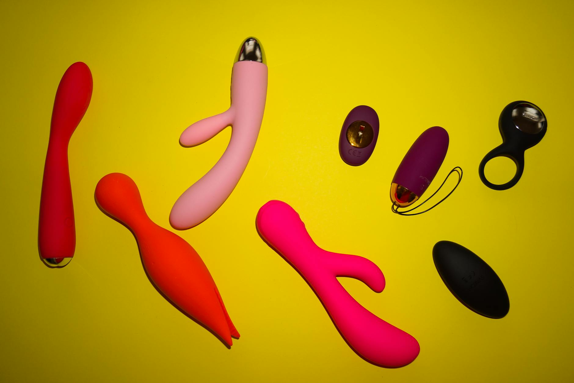 Hand holding a vibrator against a purple backdrop, representing intimate pleasure and sensation focus